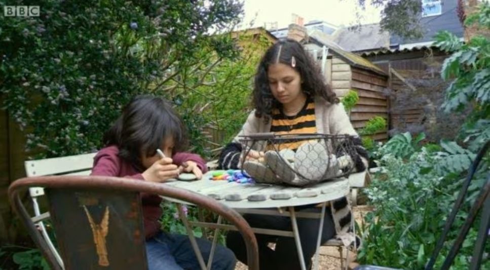 Two children sitting on an outside table