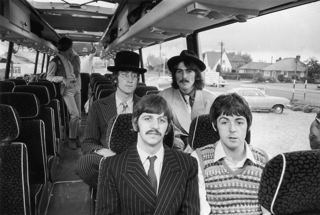 On a nearly empty tour bus, the Beatles wear eclectic outfits—Ringo in pinstripes, Paul in a sweater vest, John in a bowler hat. It’s ‘60s psychedelia meets business casual.