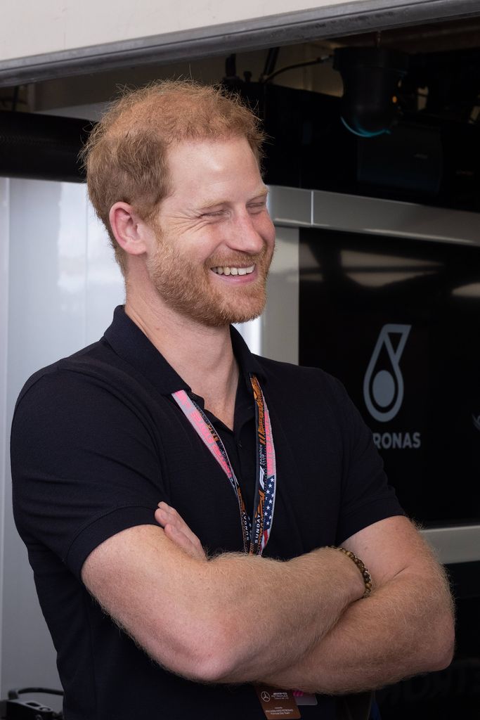 Prince Harry smiling in a short sleeved top