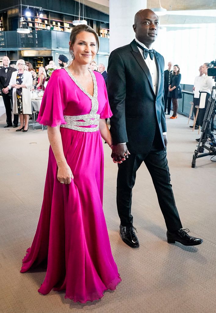 Princess Martha-Louise and Durek Verrett holding hands in smart dress