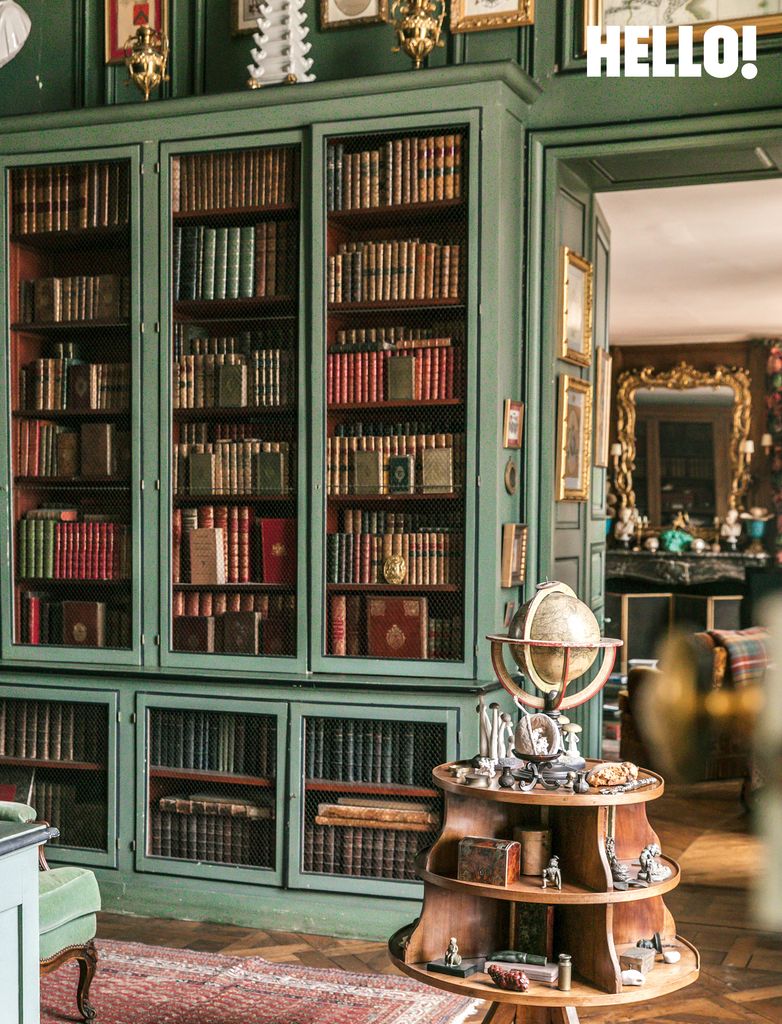 The green bookcase holding antique volumes in the library at Château de Sourches
