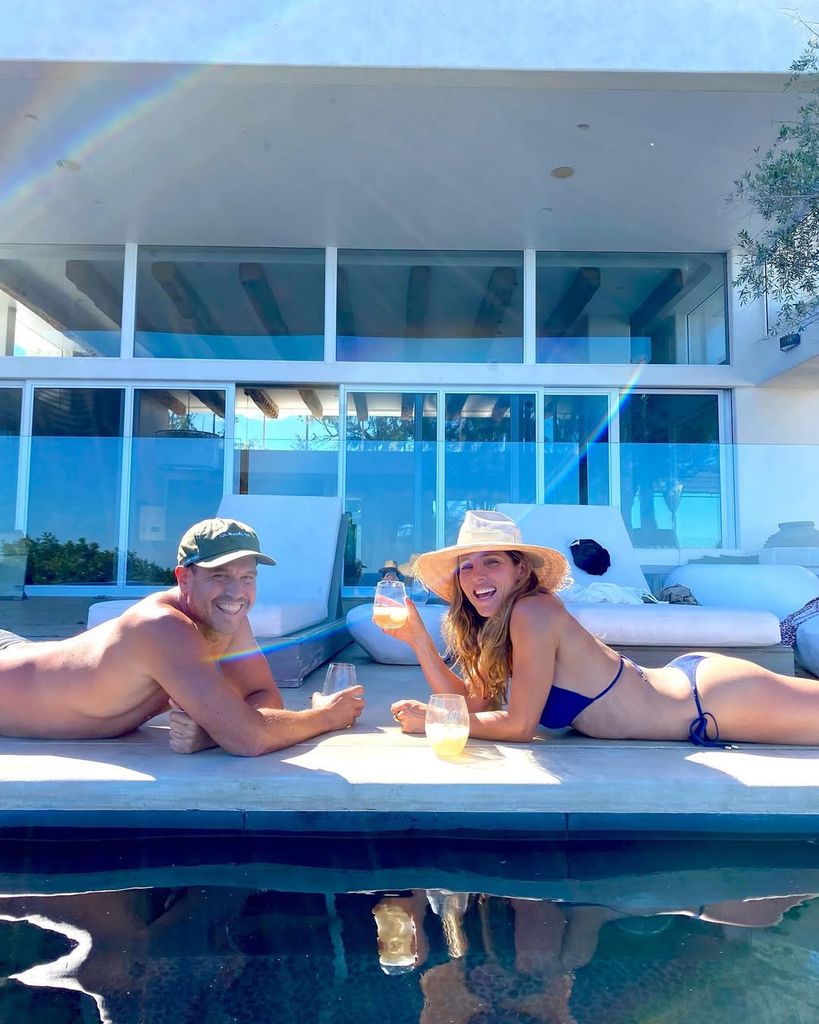 Elsa Pataky and a friend lie on the pool terrace with a drink in hand while sunbathing