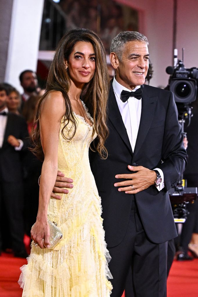 A beaming George posed alongside his glamorous wife Amal