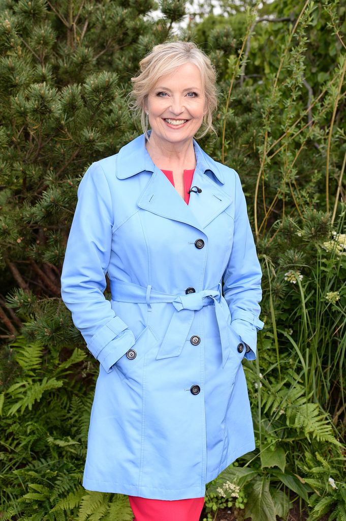Carol Kirkwood in a baby blue coat and red dress