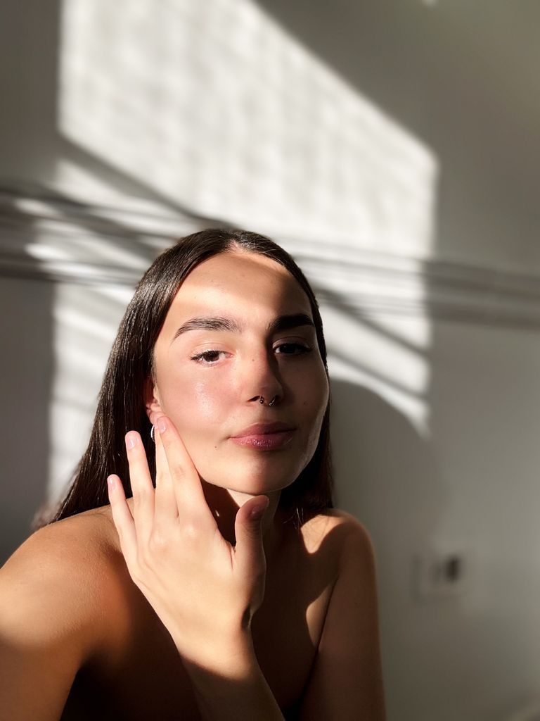 Selfie of a young woman having her beauty routine at home