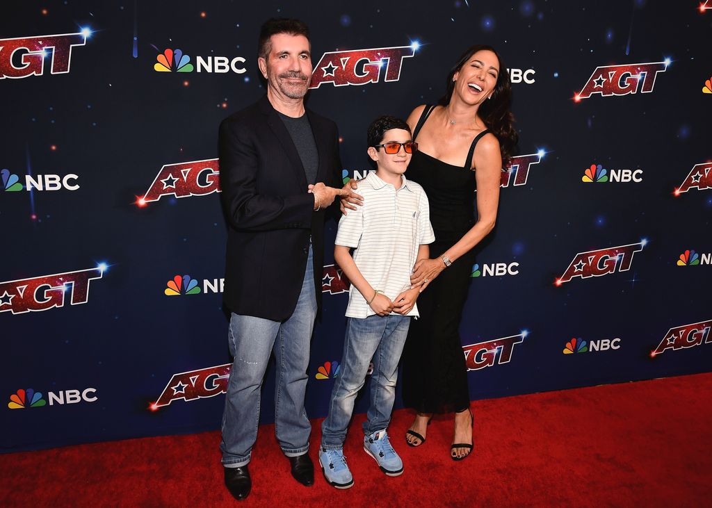 Simon Cowell posing with his son Eric and fiancée Lauren Silverman backstage at AGT