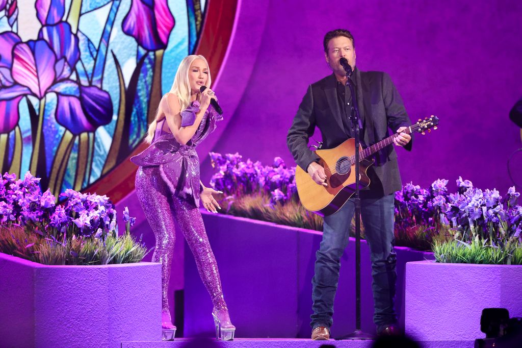 Gwen Stefani em macacão roxo brilhante se apresentando com Blake Shelton no ACMAs 