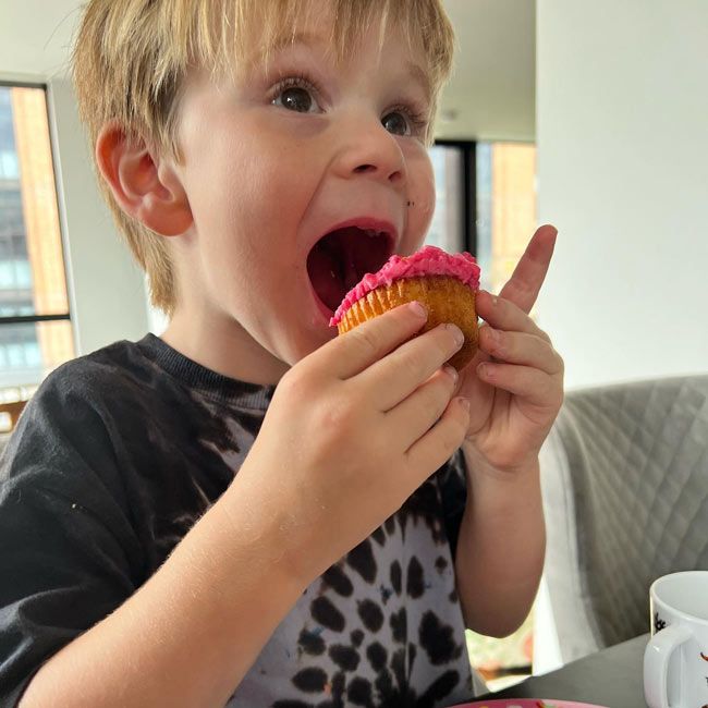 oscar ramsay tries to fit a whole pink cupcake in his mouth