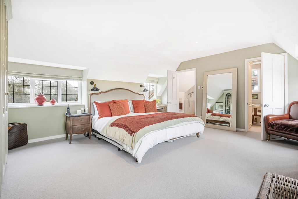 bedroom with large bed with orange cushions and bedspread