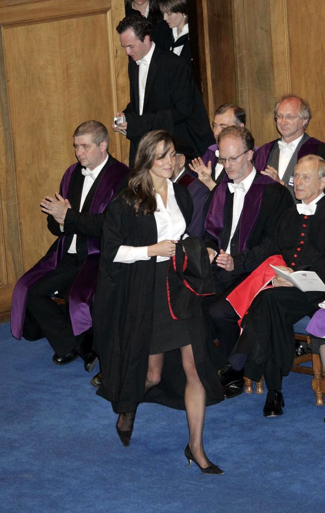 Kate collects degree in a collarless shirt and black pencil skirt