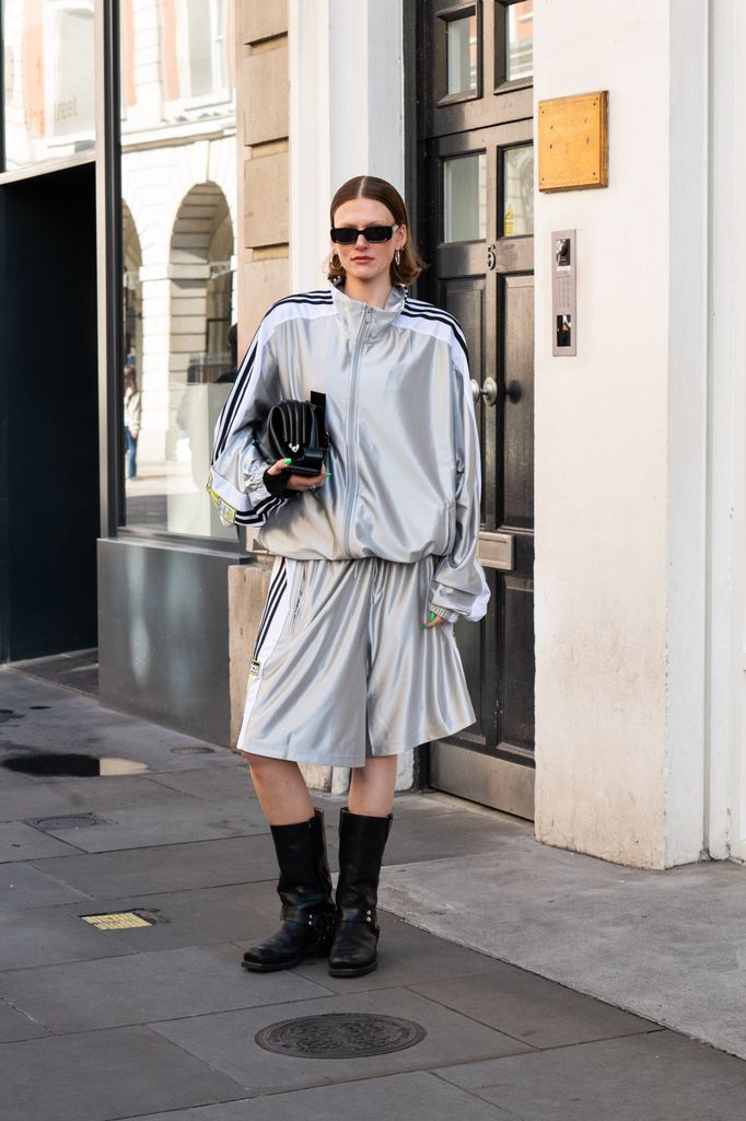  Olivia Catchpole wears a Osoi bag, Harley Davidson boots, Gucci sunglasses, Adidas jacket and shorts outside the Bora Aksu show during London Fashion Week