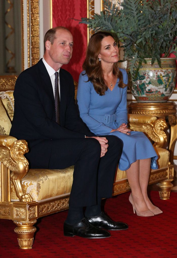 Kate Middleton projetait une « douce autorité » dans une robe midi ceinturée 1 William et Kate assis dans une chambre rouge sur une chaise dorée