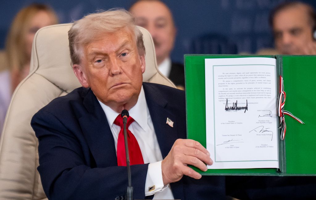 Donald Trump shows the signed peace treaty at the Gaza summit chaired by Egypt's President Al-Sisi