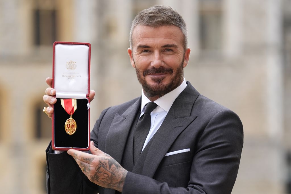 David Beckham holding a medal after becoming a knight