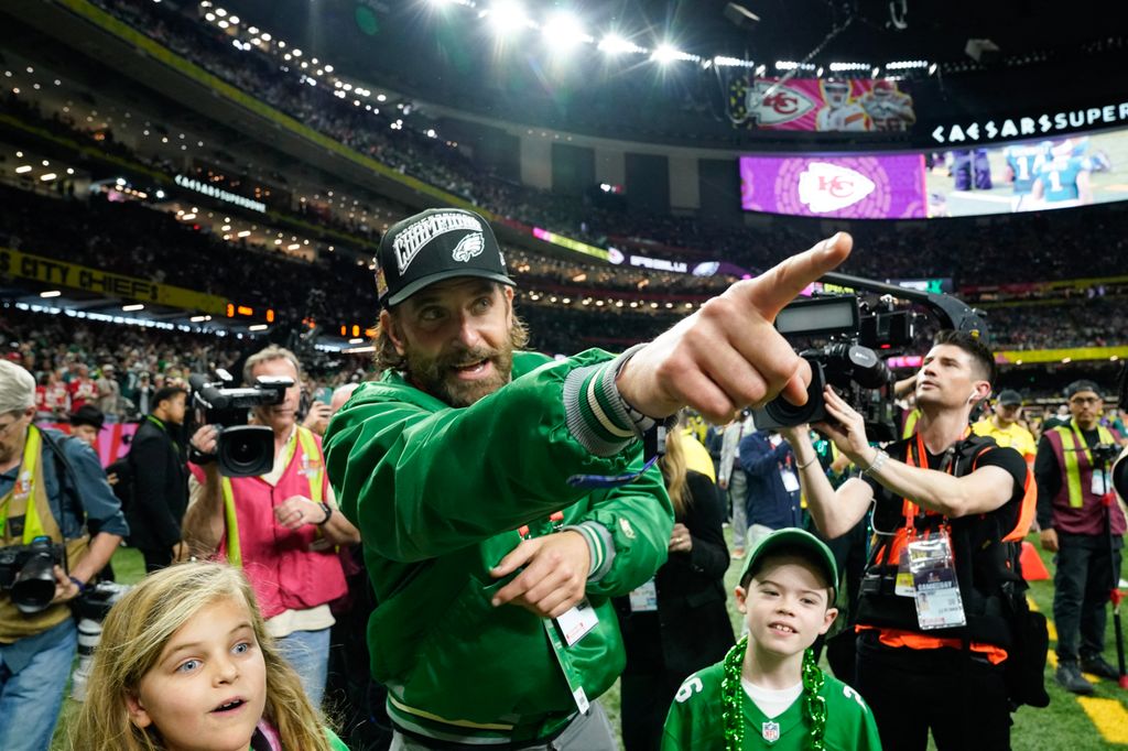 Bradley Cooper walks the sidelines before the start of Super Bowl