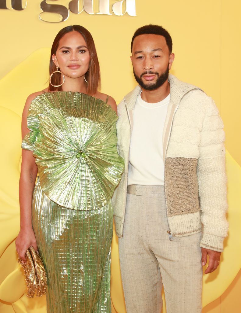 Chrissy Teigen and John Legend with yellow backdrop