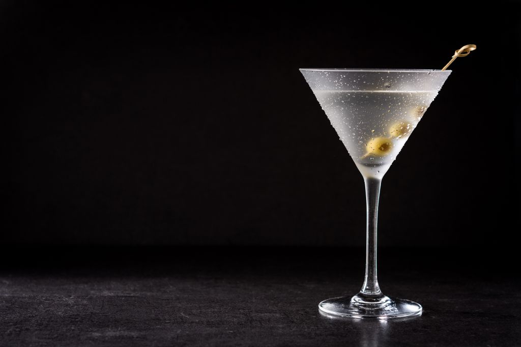 Classic Dry Martini with olives on black background