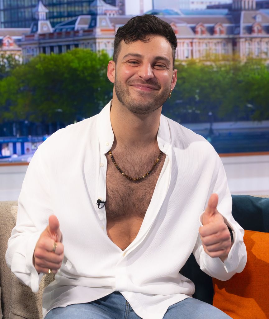 Vito Coppola giving a 'thumbs up' in a semi-open shirt