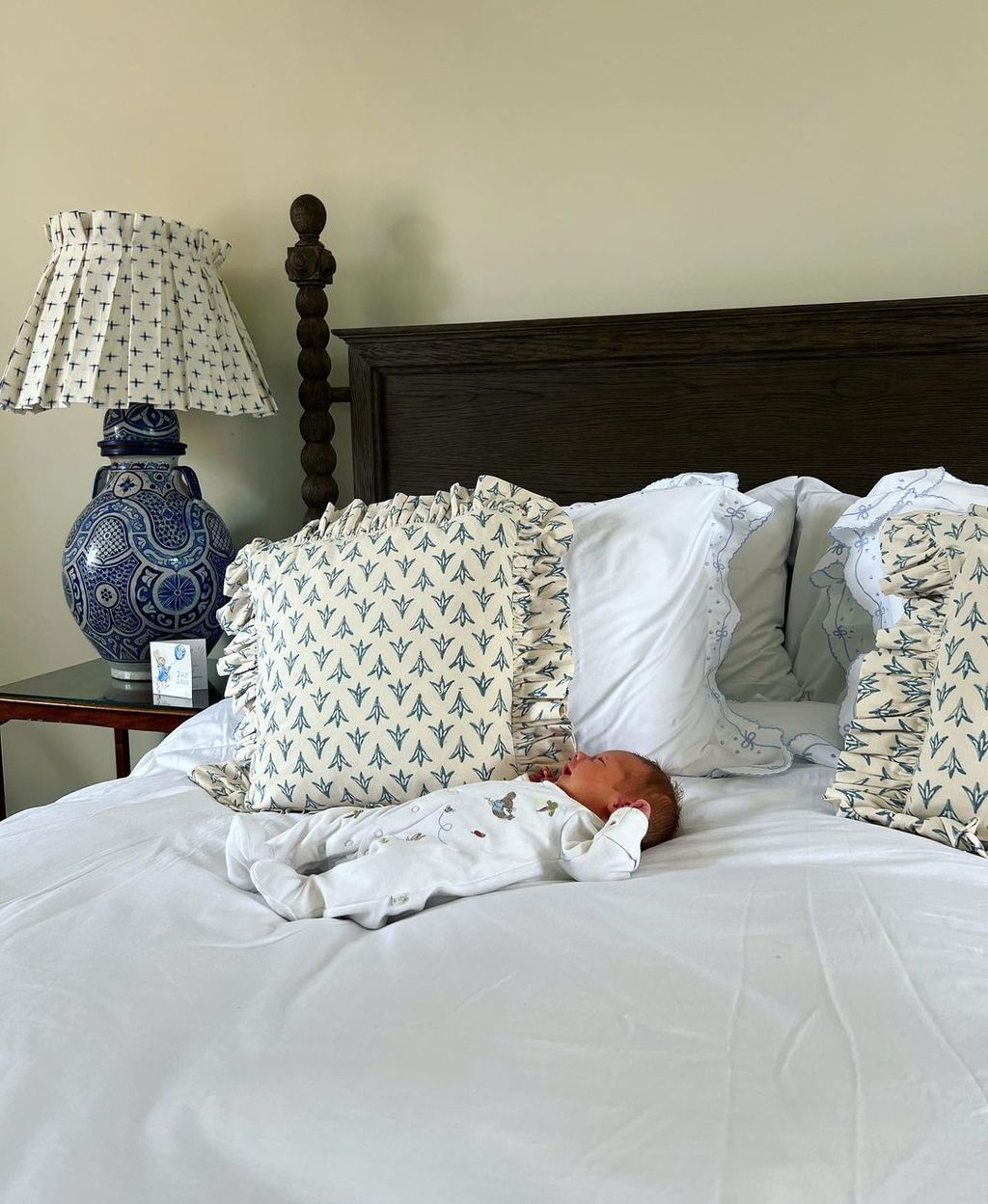 A baby asleep on a white bed