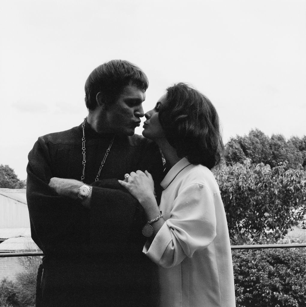 Richard Burton and Elizabeth Taylor leaning in for a kiss on the set of Becket