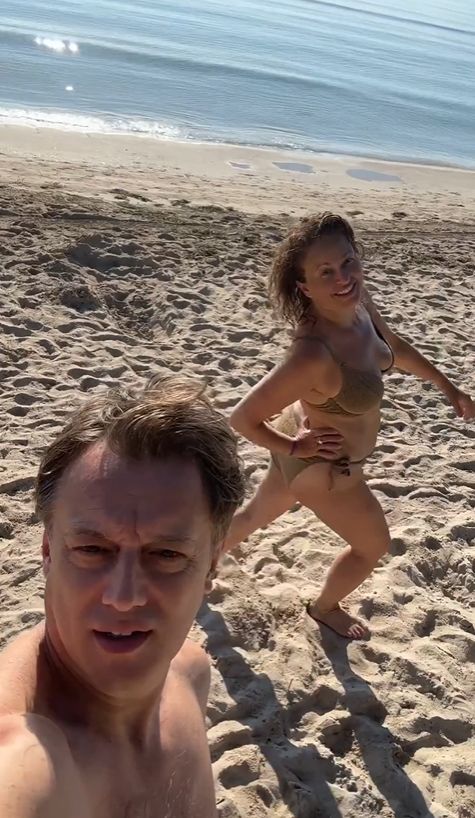 Nadia Sawalha in bikini with Mark Adderley on a beach