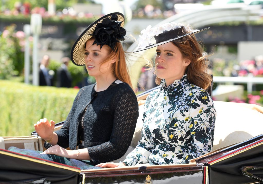 Princess Beatrice in a black dress and Princess Eugenie in a floral dress - both are riding in a carriage