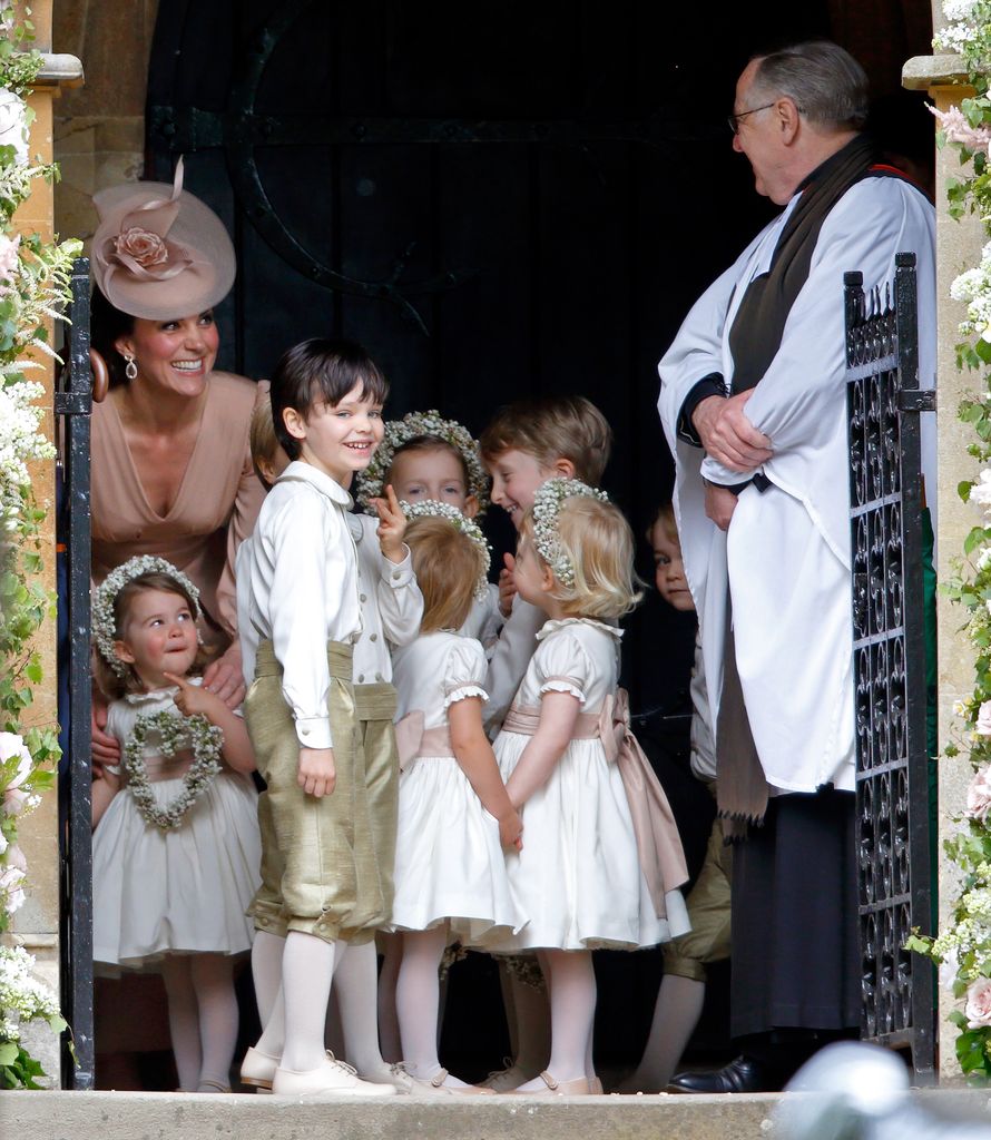 Kate shares a giggle with the vicar and the bridal party