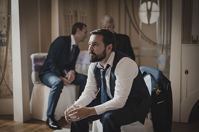 Martin Compston as Jimmy sits in suit in Mayflies