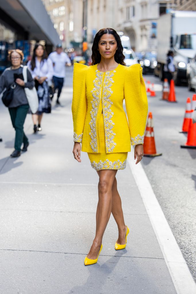 Camila Alves McConaughey wears yellow skirt, jacket with strong shoulder line outside Carolina Herrera during New York Fashion Week on September 09, 2024 in New York City