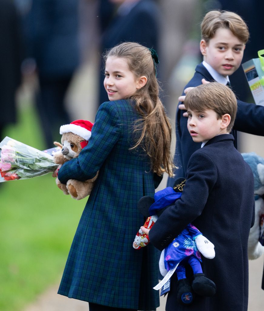 Prince George, Princess Charlotte and Prince Louis looking over their shoulders in blue coats