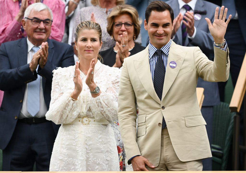Mirka Federer in a white dress clapping with Roger Federer courtside on day two of the Wimbledon 2023
