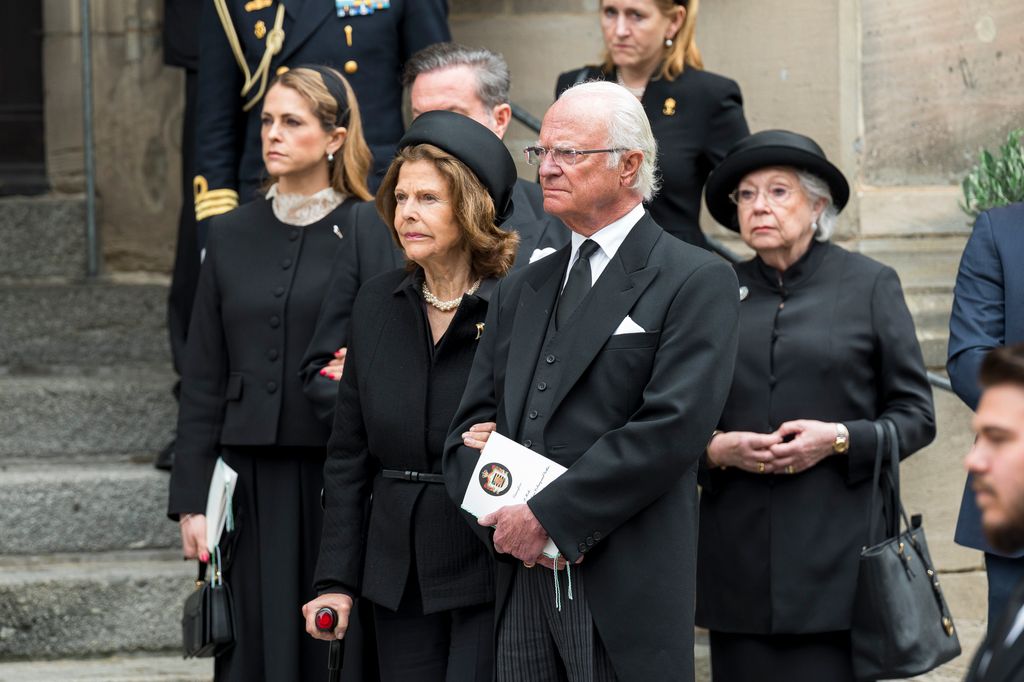 Princess Madeleine of Sweden stands with her husband Christopher O'Neill, as well as Queen Silvia of Sweden after the funeral service for Prince Andreas of Saxe-Coburg and Gotha