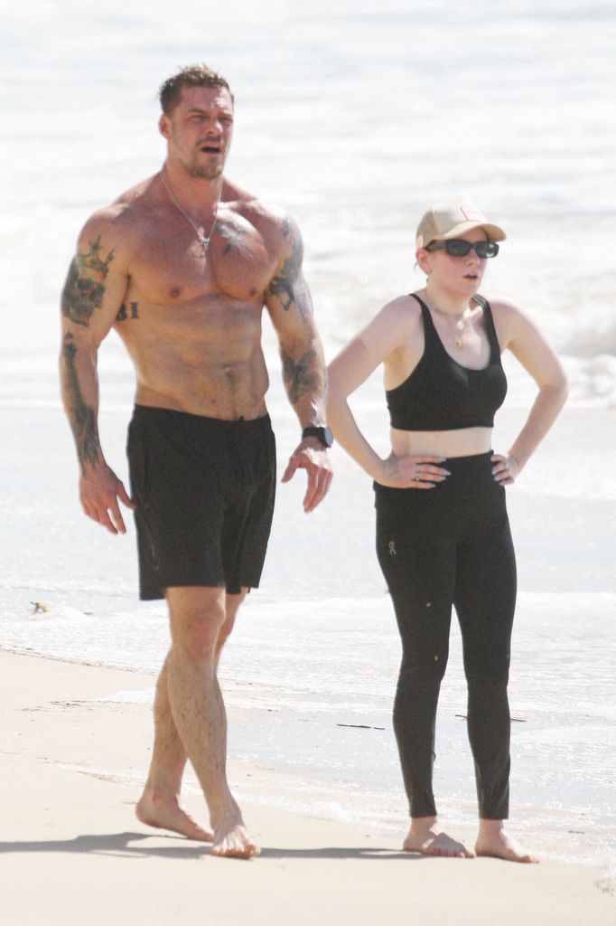 Alan and his wife walk on the coast after a run as he showed off his tattooed body 