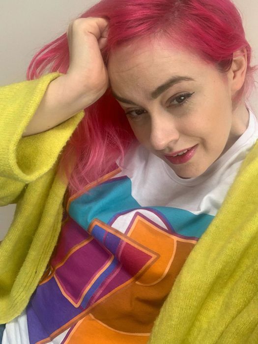 Woman with parkinsons wearing brightly coloured clothes with pink hair