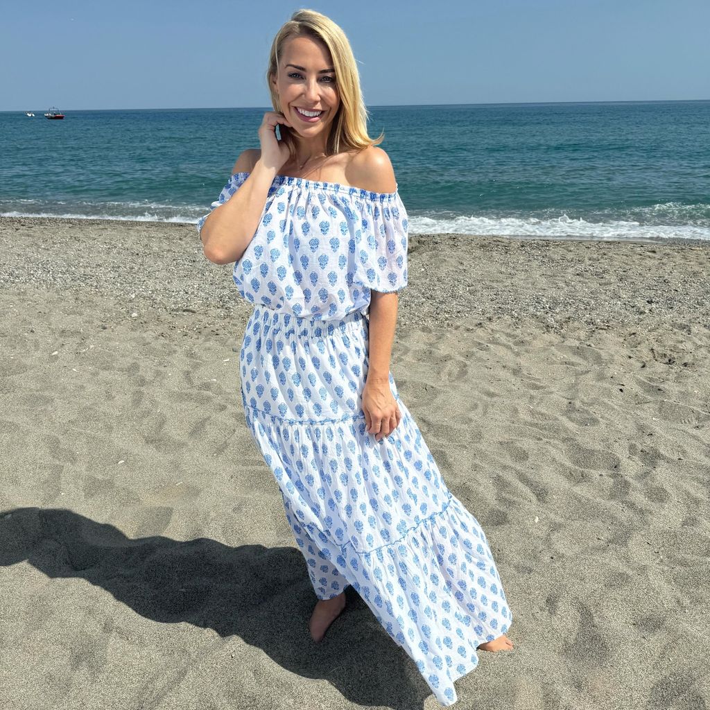 Laura Hamilton in a blue dress on the beach