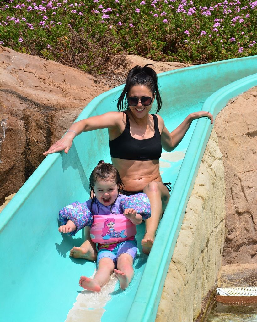 Sam quek on slide in waterpark with daughter