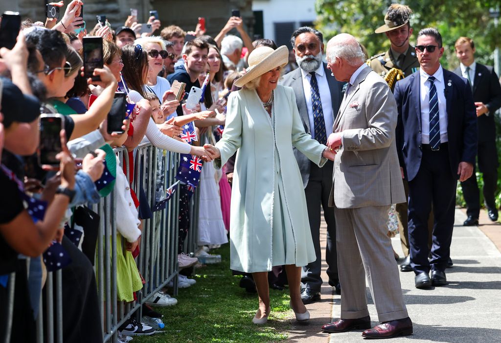 Queen Camilla speaks with King Charles III as they greet the crowd during a visit to St. Thomas's Anglican Church