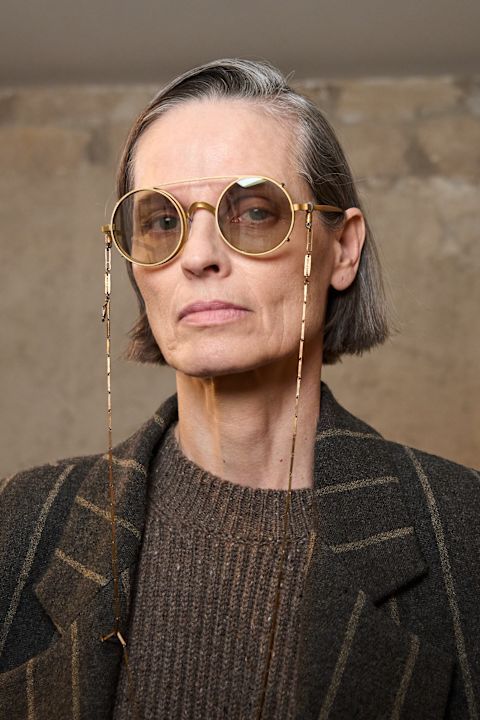 An older model with round sunglasses backstage at Uma Wang