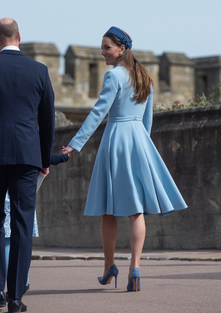 Kate Middleton usando uma faixa na cabeça e um casaco azul ao lado do príncipe William, príncipe George e princesa Charlotte participam do tradicional culto de domingo de Páscoa na Capela de St Georges, no terreno do Castelo de Windsor, em 17 de abril de 2022