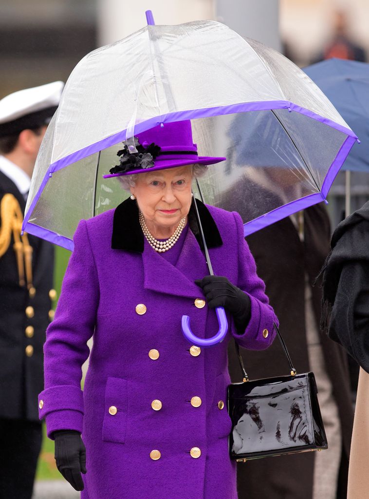 Rainha Elizabeth com casaco roxo com gola escura