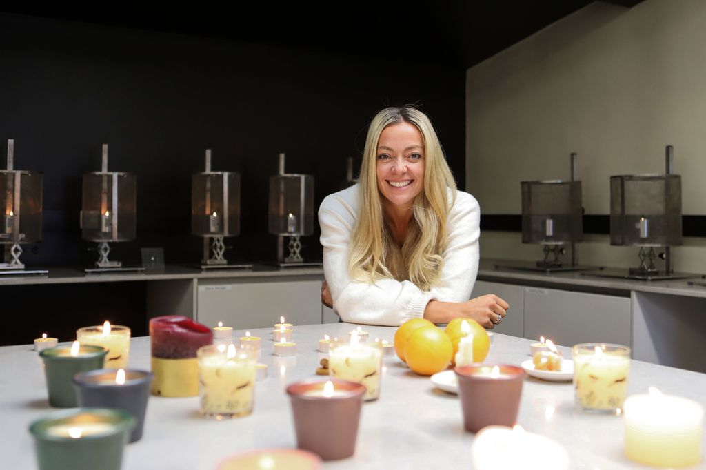 Cherry Healey leaning on a desk featuring candles