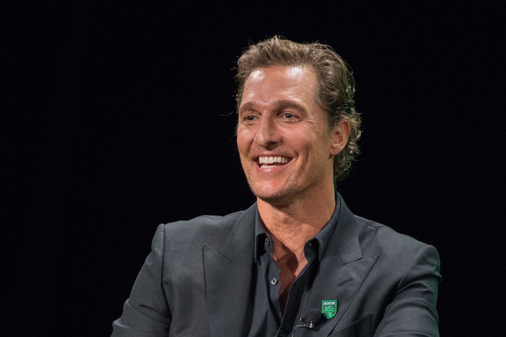 Matthew McConaughey laughs on stage during event