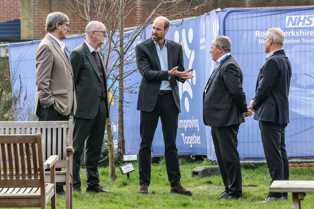 Prince William stands next to a Cherry tree planted in memory of Nurse Julie Edward