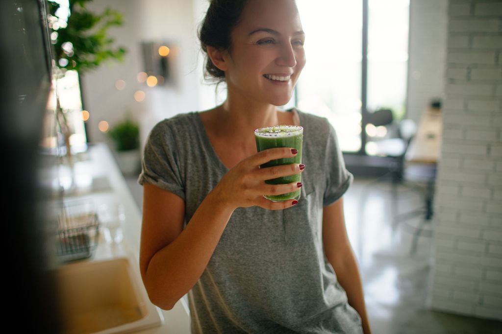 Photo of a young smiling woman having healthy breakfast in the morning