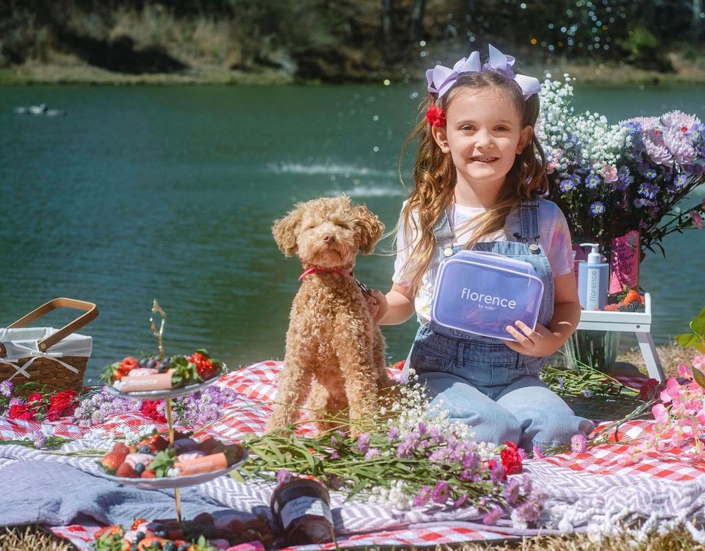 Millie Bobby Brown's sister sitting in front of a lake with her dog