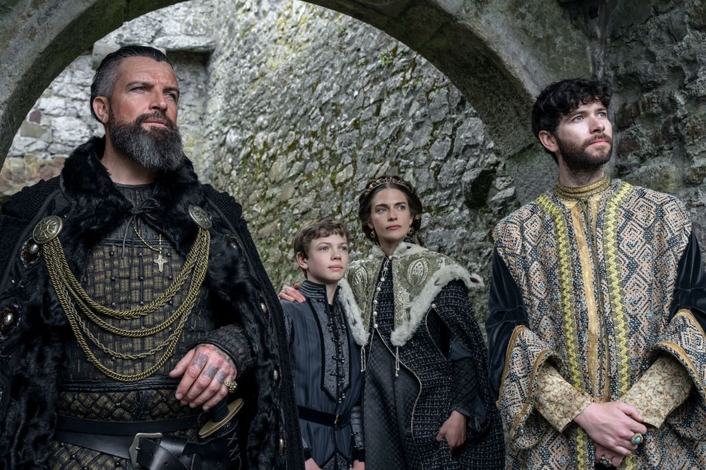 group of people in period clothing under brick arch