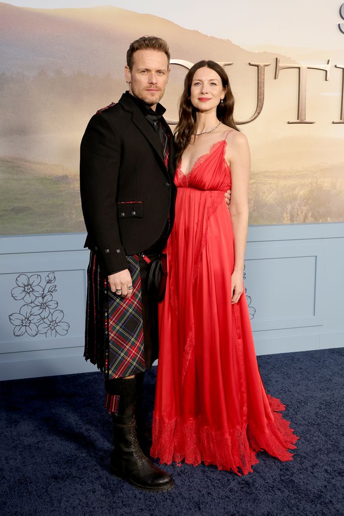 Caitríona Balfe d'Outlander vole la vedette dans une robe rouge soyeuse lors de la première de la dernière saison 2 photo de Caitriona Balfe en longue robe rouge et de Sam Heughan en kilt lors de la première de la saison 8 d'Outlander