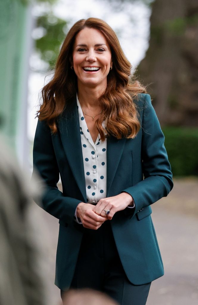Kate smiling in forest green suit
