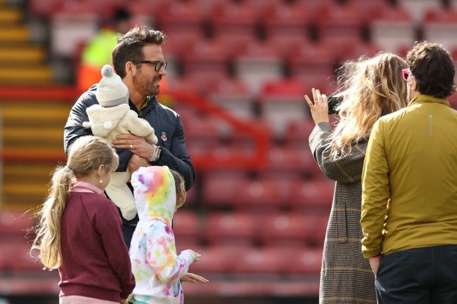 ryan reynolds holds newborn baby as blake lively takes pictures