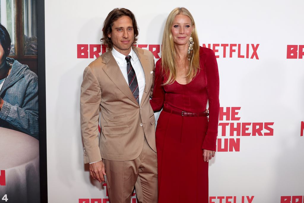 Brad Falchuk in beige suit and Gwyneth Paltrow in red dress at the Los Angeles Premiere Of Netflix's "The Brothers Sun" at Netflix Tudum Theater on January 04, 2024 in Los Angeles, California